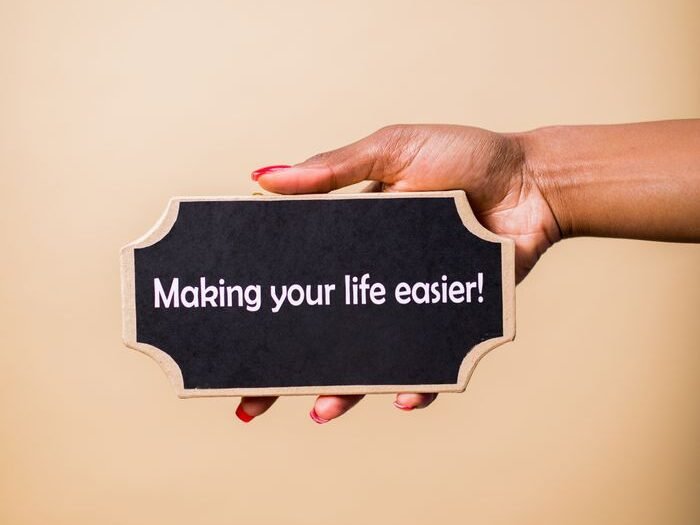 Close-up of a hand holding a sign that reads 'Making your life easier.' Perfect for motivational content.
